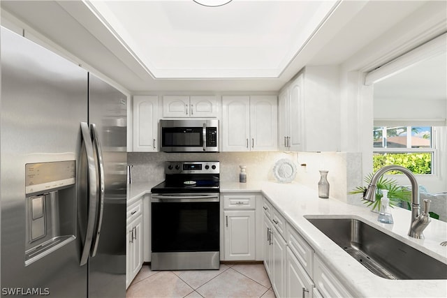 kitchen with white cabinets, sink, appliances with stainless steel finishes, and light tile floors