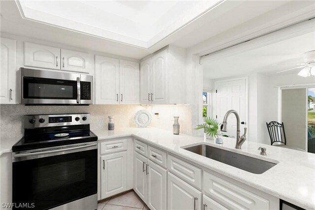 kitchen with a healthy amount of sunlight, stainless steel appliances, and white cabinetry