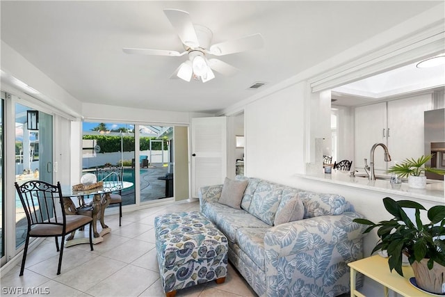 living area featuring ceiling fan, light tile patterned flooring, and visible vents