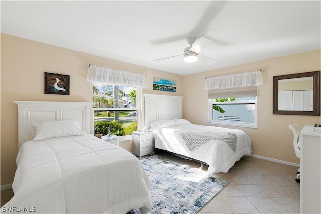 tiled bedroom featuring a ceiling fan and baseboards