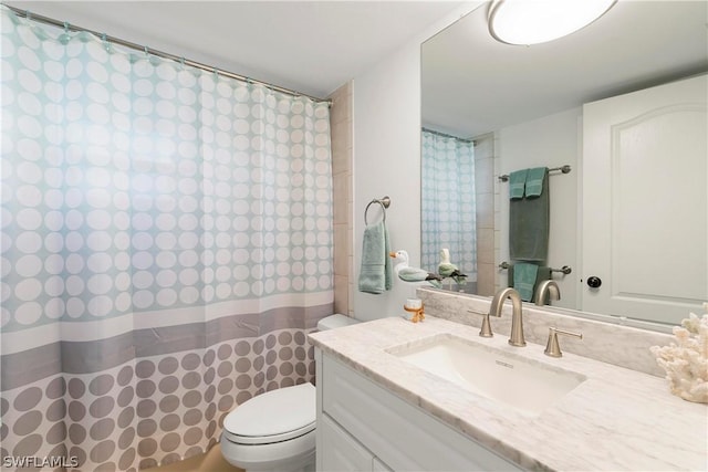 bathroom with a shower with shower curtain, vanity, and toilet