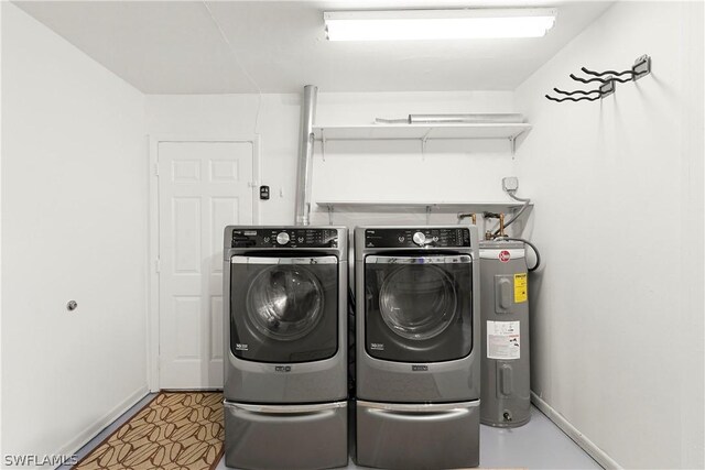 laundry room with washing machine and clothes dryer, tile floors, and electric water heater