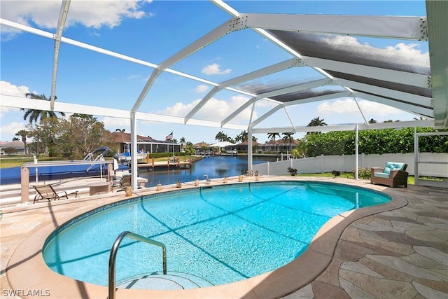 outdoor pool with a patio, a water view, fence, and glass enclosure