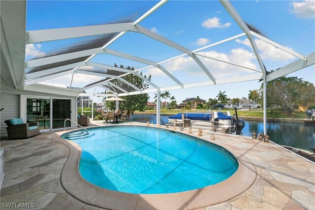 view of swimming pool featuring a patio area, a water view, and glass enclosure