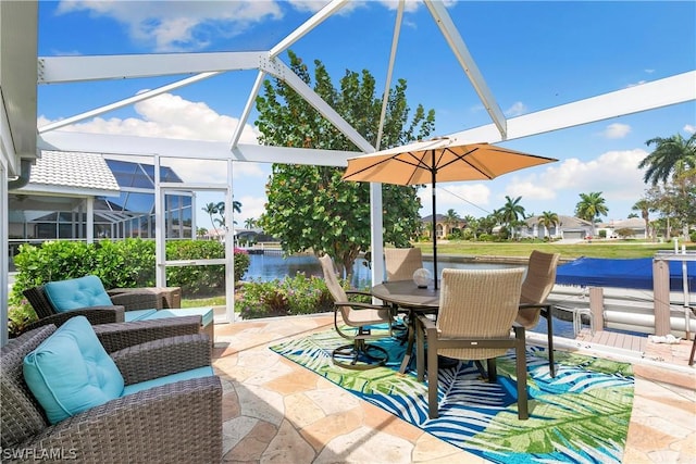 view of patio / terrace featuring glass enclosure and a water view