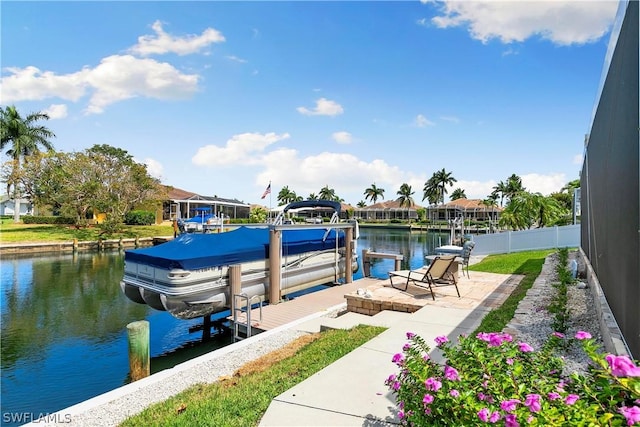 view of dock featuring a water view, fence, and boat lift