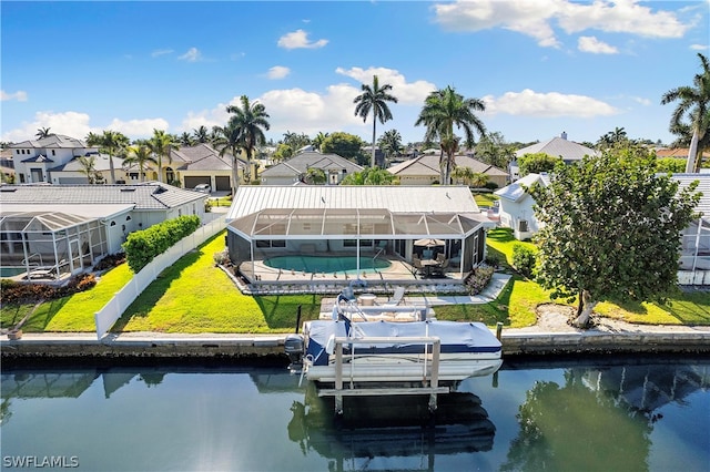 view of dock with glass enclosure, a lawn, and a water view