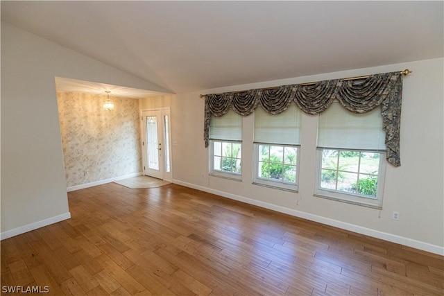 unfurnished room with french doors, wood-type flooring, and lofted ceiling