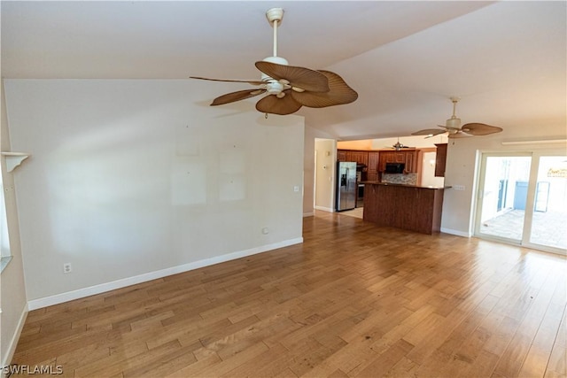 unfurnished living room with lofted ceiling and light wood-type flooring