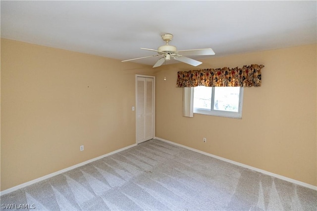 carpeted spare room with ceiling fan