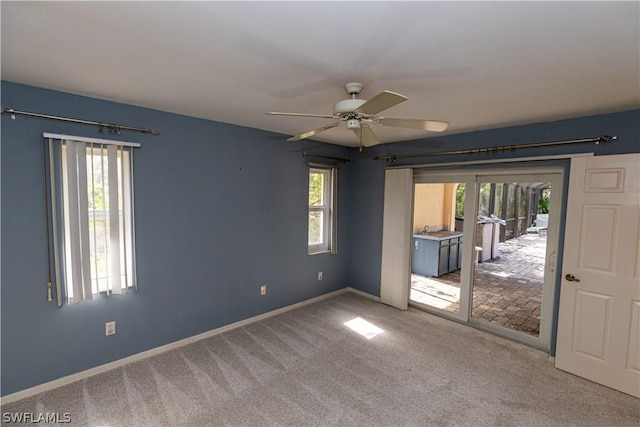 empty room with ceiling fan, carpet floors, a wealth of natural light, and french doors