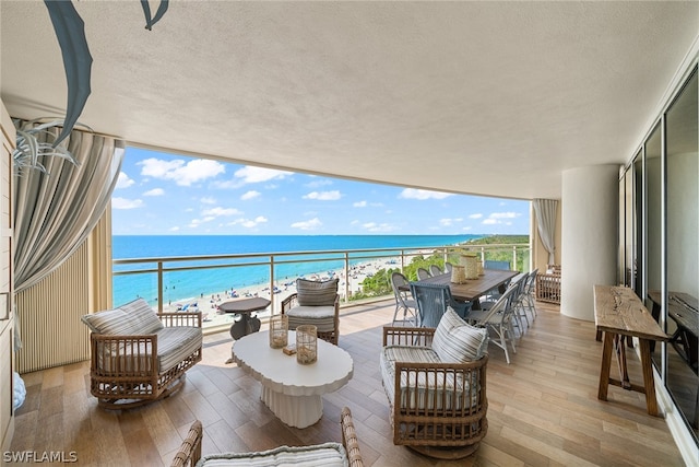 balcony featuring a beach view and a water view