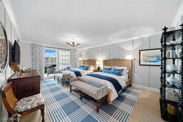 bedroom featuring light hardwood / wood-style flooring, crown molding, and a chandelier