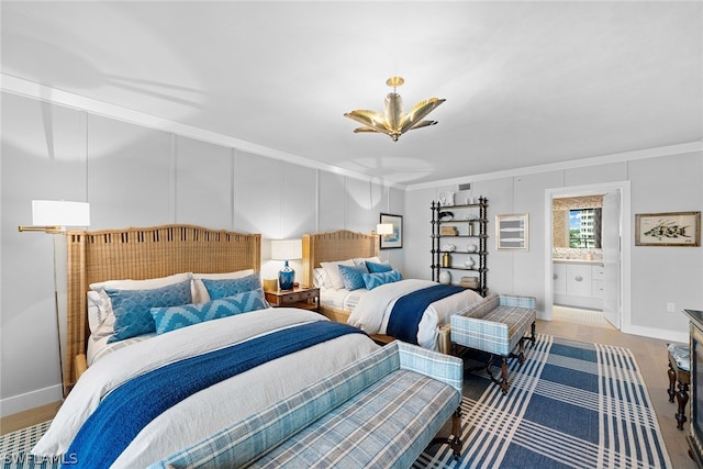 bedroom featuring ornamental molding, ensuite bath, and hardwood / wood-style flooring