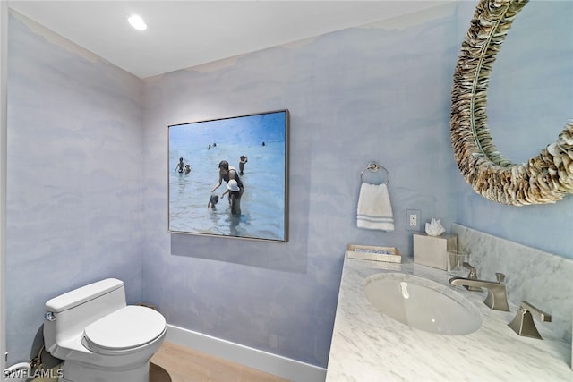 bathroom featuring wood-type flooring, oversized vanity, and toilet