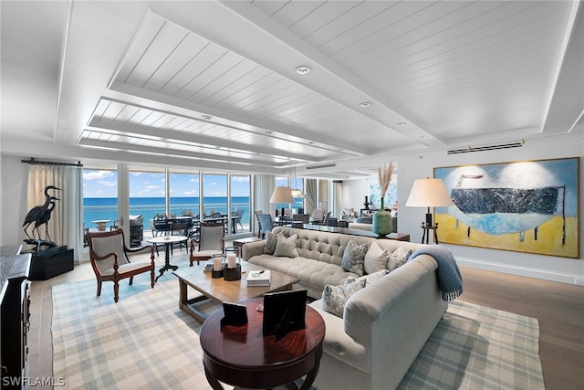 living room featuring a water view, hardwood / wood-style flooring, and beamed ceiling