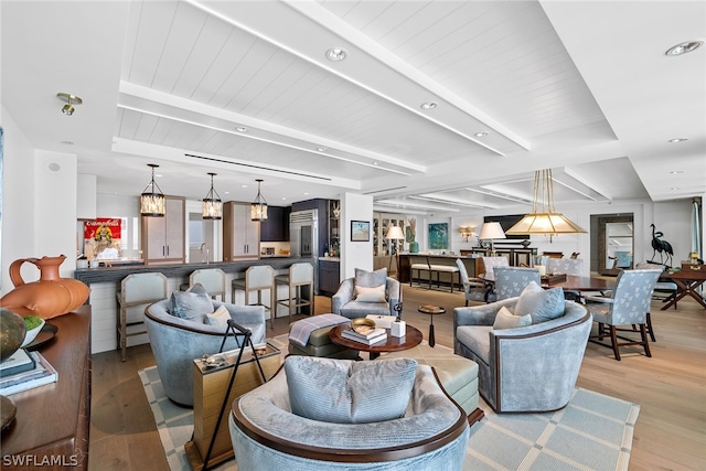 living room with beamed ceiling and light hardwood / wood-style flooring