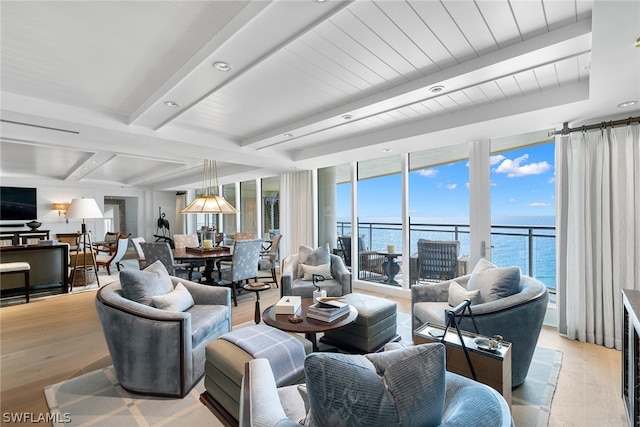 living room featuring beamed ceiling, light hardwood / wood-style floors, a water view, and a wall of windows