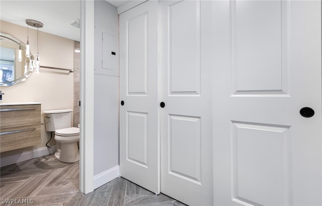 bathroom featuring vanity, parquet floors, and toilet