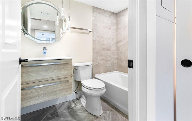 full bathroom featuring vanity, tiled shower / bath combo, and toilet