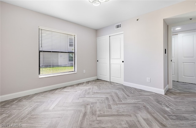 unfurnished room with light parquet flooring