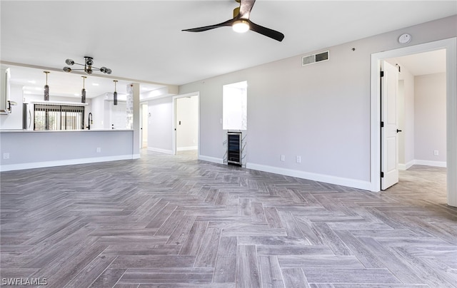 unfurnished living room with parquet flooring, sink, and ceiling fan