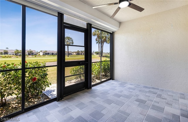 unfurnished sunroom with ceiling fan