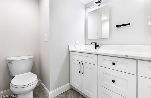 bathroom with tile floors, oversized vanity, and toilet