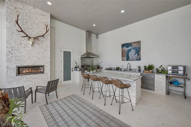 view of patio / terrace featuring a fireplace, an outdoor kitchen, and a wet bar