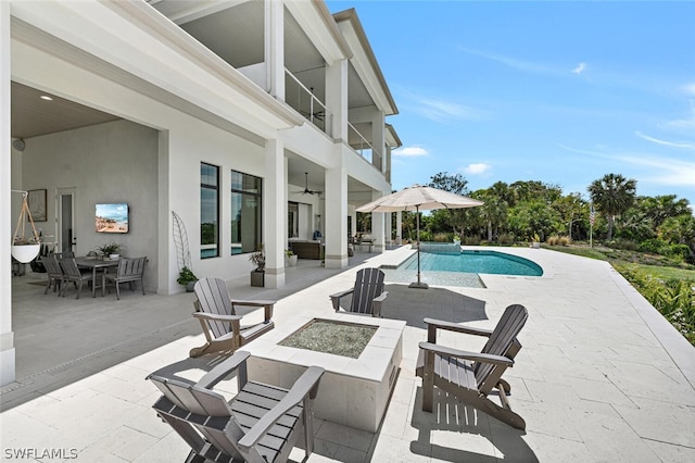 view of pool featuring an outdoor fire pit, a patio area, and ceiling fan