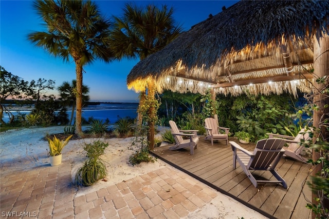 patio terrace at dusk with a gazebo and a water view