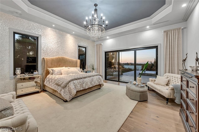 bedroom featuring access to exterior, ornamental molding, a tray ceiling, and light hardwood / wood-style floors