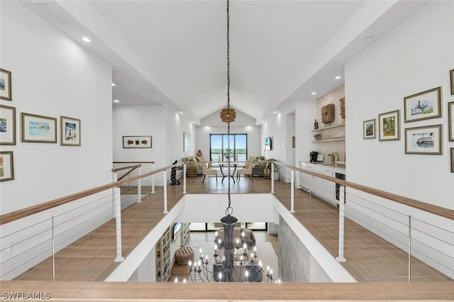 hallway featuring an inviting chandelier and lofted ceiling