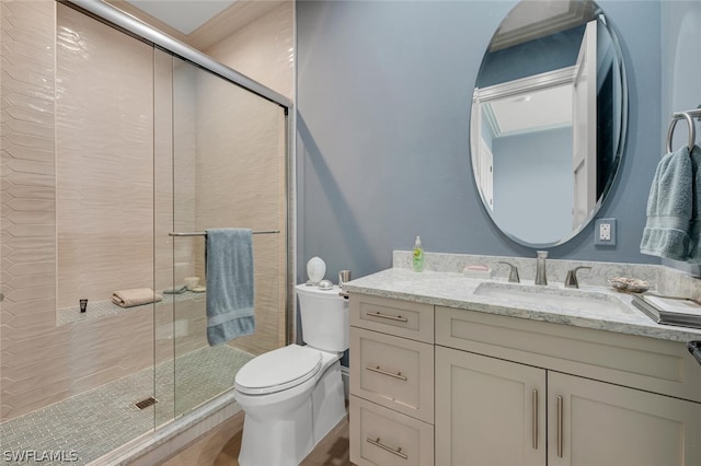 bathroom with vanity, toilet, and a shower with door