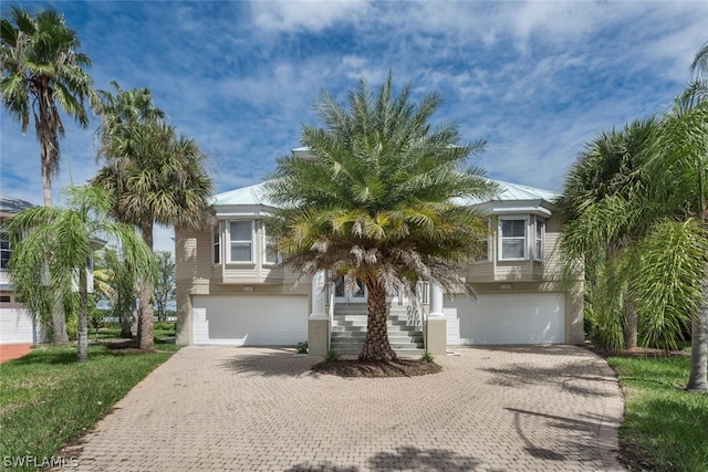 raised beach house featuring a garage