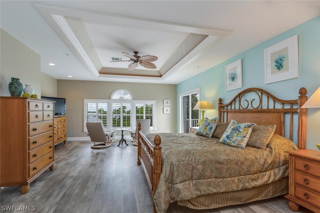 bedroom featuring dark wood-type flooring, ceiling fan, and a raised ceiling