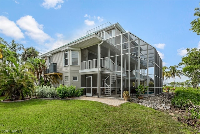 back of property with a yard, a lanai, a balcony, and a patio