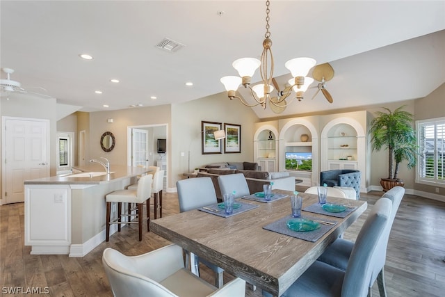 dining room with built in shelves, dark hardwood / wood-style flooring, sink, and ceiling fan with notable chandelier