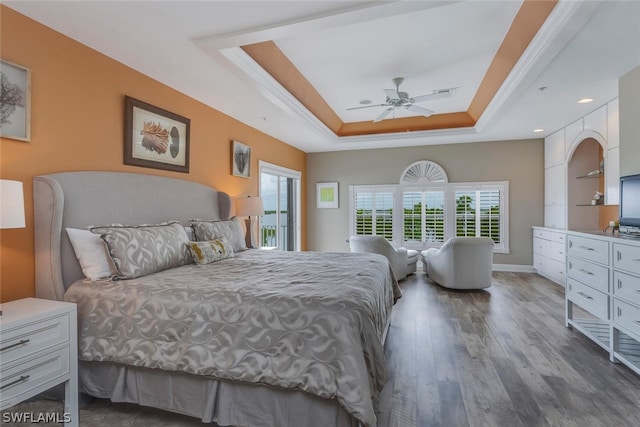 bedroom with a tray ceiling, ceiling fan, and dark hardwood / wood-style flooring