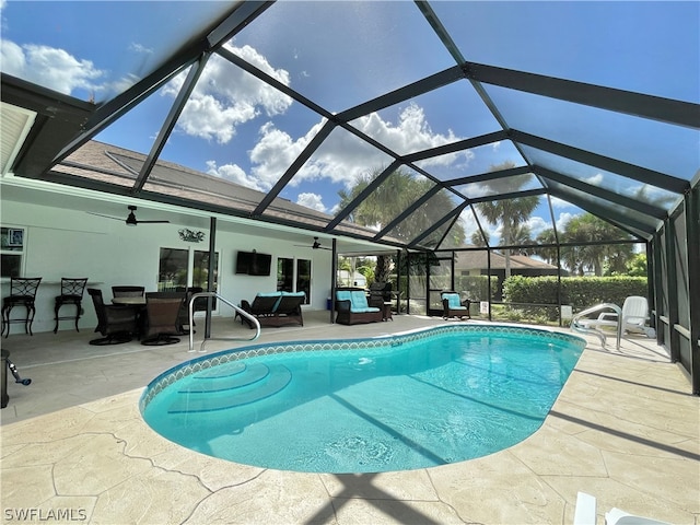 view of pool with an outdoor living space, a lanai, and ceiling fan