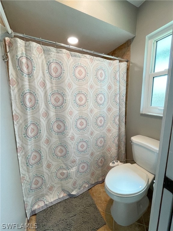 bathroom featuring toilet and tile floors