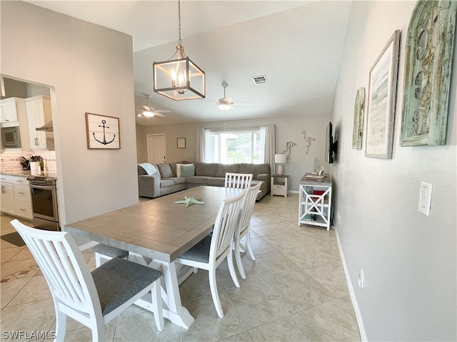 dining space with light tile flooring and ceiling fan with notable chandelier