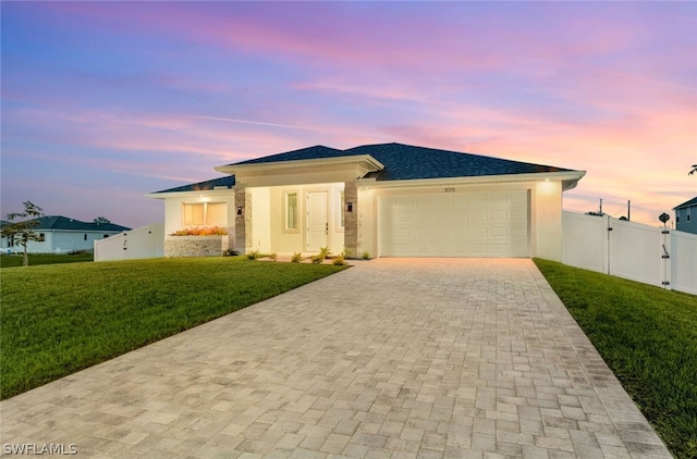 view of front of home featuring a garage and a lawn