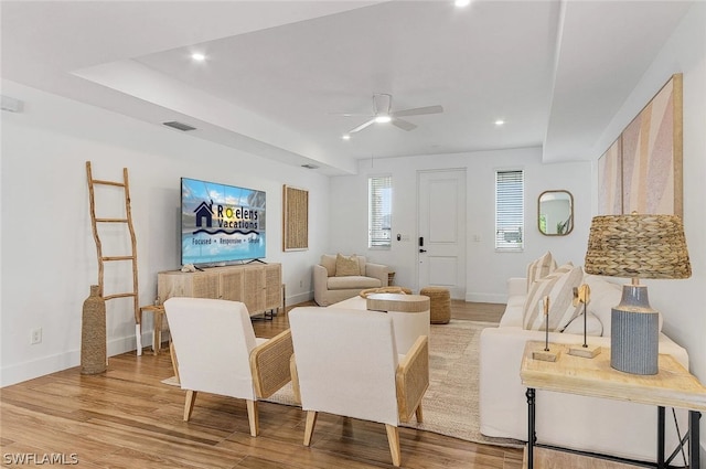 living room featuring wood-type flooring and ceiling fan