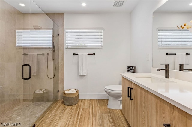 bathroom featuring a wealth of natural light, toilet, and large vanity