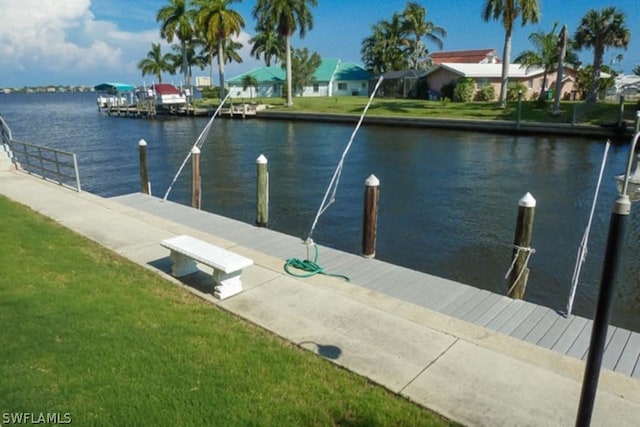 dock area featuring a water view and a lawn