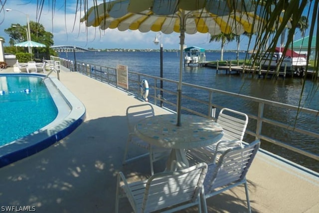 view of swimming pool with a patio and a water view