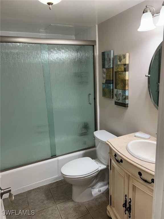 full bathroom with tile patterned flooring, enclosed tub / shower combo, vanity, and toilet