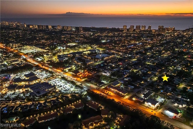 aerial view at dusk featuring a water view