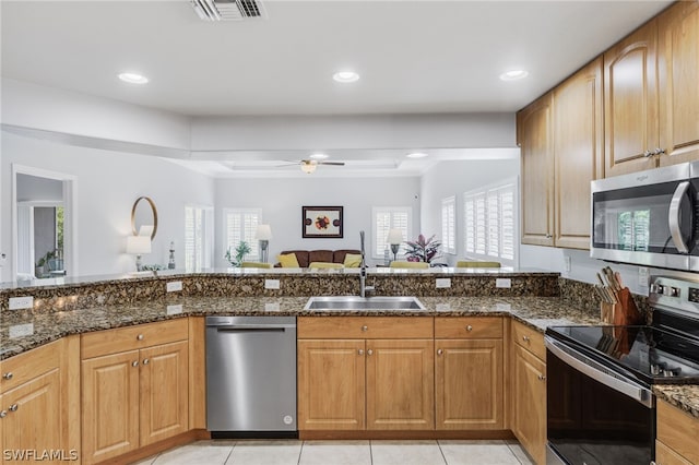 kitchen featuring ceiling fan, sink, appliances with stainless steel finishes, and dark stone countertops